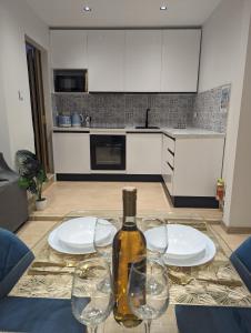 a bottle of wine sitting on a table with glasses at Modern & Cosy 1 Bed Maisonette - Close to Salina Bay in St. Paul's Bay