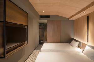 a bedroom with two beds and a flat screen tv at Hotel Keihan Tenmabashi Ekimae in Osaka