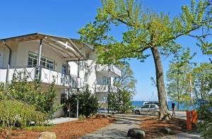 una casa con un albero davanti di Appartementhaus am Strand m Balkon Göhren OR 01-09 a Göhren