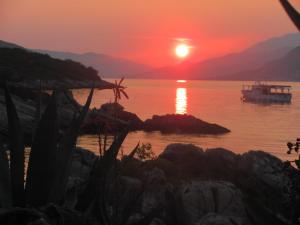 a boat in the water at sunset at Holiday Home Brinic in Tivat