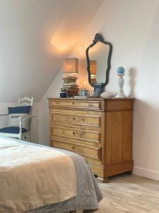 a bedroom with a dresser with a mirror on it at Maison d'hôtes du Carrec in Paimpol