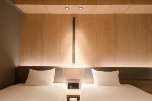 سرير أو أسرّة في غرفة في Hotel Keihan Tenmabashi Ekimae