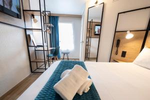 a hotel room with a towel on a bed at ibis Avignon Centre Pont De L'Europe in Avignon