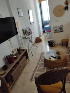 ein Wohnzimmer mit einem Flachbild-TV und einem Tisch in der Unterkunft Appartement à Carthage byrsa in Karthago