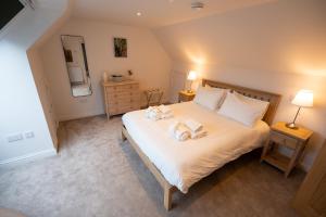 a bedroom with a bed with two towels on it at Forest Corner Luxury Home with Hot Tub in North Ballachulish
