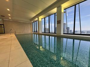 a swimming pool in a building with a view of the water at Collins Serviced Apartments in Melbourne