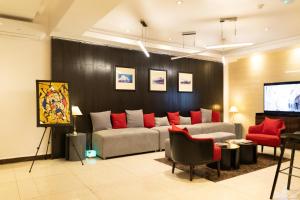 Rich Bridge Hotel في أبوجا: غرفة معيشة مع أريكة وتلفزيون بشاشة مسطحة