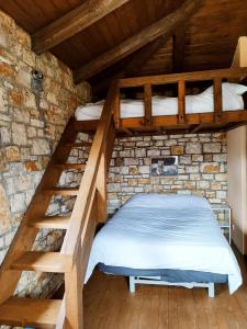 卡拉夫里塔的住宿－Erymanthos country home，卧室设有2张双层床,位于砖墙内