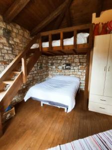 sypialnia z łóżkiem w ceglanej ścianie w obiekcie Erymanthos country home w Kalawricie