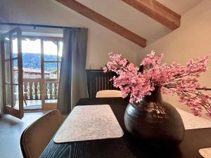 a vase with pink flowers sitting on a table at Ferienwohnung "Bergzeit" in Bad Wiessee