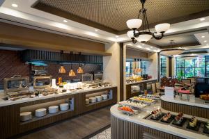 a restaurant with a buffet line with food on display at Swiss-Belhotel Airport Yogyakarta in Temon