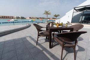 a table and chairs on a patio next to a pool at براديس لاقون شهد الاريج 4 غرف بمسبح خاص in Durat  Alarous