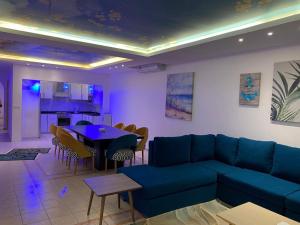 sala de estar con sofá azul y mesa en براديس لاقون شهد الاريج 4 غرف بمسبح خاص en Durat  Alarous