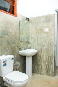 La salle de bains est pourvue de toilettes et d'un lavabo. dans l'établissement Saimon Villa, à Mirissa