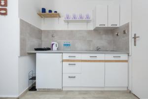eine Küche mit weißen Schränken und einem Waschbecken in der Unterkunft Krab in Rewal