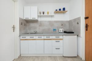 uma cozinha com armários brancos e um lavatório em Krab em Rewal