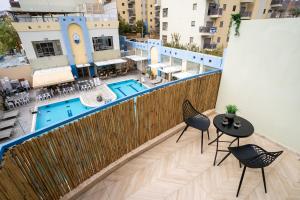 an apartment balcony with a table and chairs and a pool at Almogim Suites Eilat in Eilat