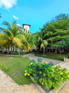 a park with palm trees and flowers in front of a building at Cloud9 Studio Tiara Desaru in Desaru