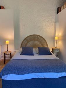 a bedroom with a large bed with blue pillows at La Clef du Four in Plesder