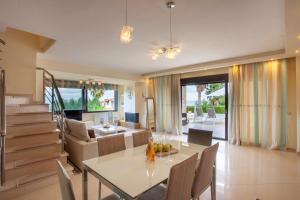 a dining room and living room with a table and chairs at Perfect view Villa Deny with 6 bedrooms and heated pool in Hanioti