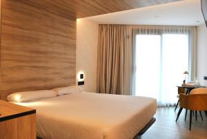 a hotel room with a bed and a window at Hotel Delfin Azul in A Lanzada