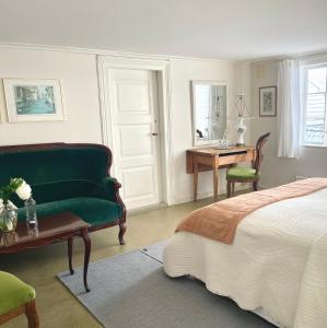 a bedroom with a bed and a green couch and a desk at Reinertsenhuset in Skudeneshavn