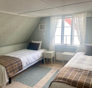 1 dormitorio con 2 camas y ventana en Reinertsenhuset en Skudeneshavn