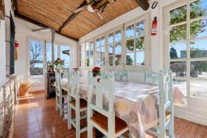 a dining room with a table and chairs and windows at Villa Fina in Deltebre