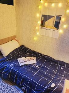 a bedroom with a blue bed with a book on it at The Stay Hill in Seoul