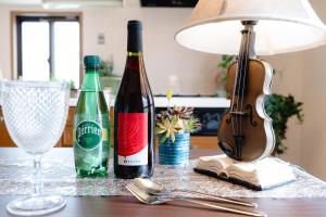 two bottles of wine and a lamp on a table at 最大9名まで宿泊可能三宮駅至近1フロア貸切コンドミニアム in Kobe