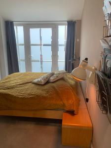 1 dormitorio con cama, lámpara y ventana en The Corner en Bergen