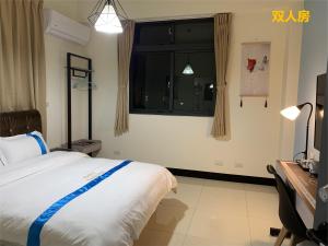 ein Schlafzimmer mit einem großen Bett und einem Fenster in der Unterkunft 塔斯汀精品民宿 in Jinning