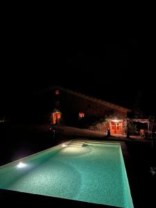 una piscina por la noche con un edificio en el fondo en La Paradella - Apartamento de uso turístico, en Arbúcies