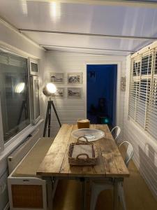 um quarto com uma mesa de madeira com um prato em Shoreline hideaway - next to the beach em Little Holland