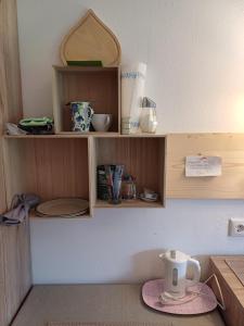 a kitchen counter with wooden shelves with a cup on a plate at Haus Barbara in Söll