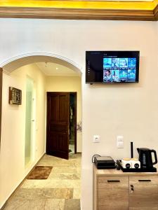 a flat screen tv on the wall of a room at Contessina Al Porto Suite in Mantoúkion