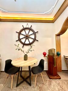 a dining room with a table and a ship wheel on the wall at Contessina Al Porto Suite in Mantoúkion