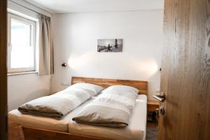 a bed with two pillows on it in a room at Appartement Haus Gosta in Gaschurn