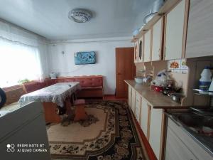 una cucina con tavolo e divano di Dastan Guest House a Naryn