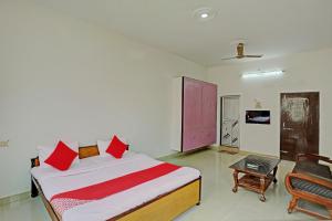 1 dormitorio con 1 cama grande con almohadas rojas en Super OYO Flagship Shivansh Paying Guest House en Varanasi