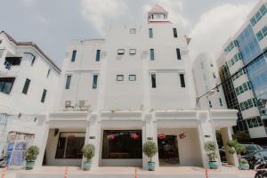 a white building with a clock tower on top at The Corner in Patong Beach