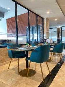 comedor con sillas azules y mesa en Salatin Hotel Palembang, en Palembang