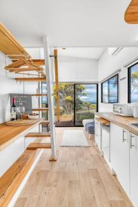 a kitchen with white cabinets and wood floors and windows at Montara Views 3 in Ararat