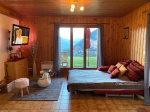 um quarto com uma cama e uma porta de vidro deslizante em Chalet Le Petit Foyer em Salvan