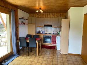 uma pequena cozinha com mesa e cadeiras em Chalet Le Petit Foyer em Salvan