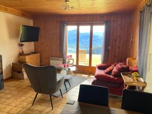 a living room with a couch and a tv at Chalet Le Petit Foyer in Salvan
