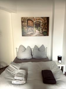 uma cama branca com duas almofadas em cima em Gemütliches Appartement "Emma" in Halle em Rusches Hof