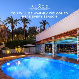 a swimming pool in front of a building at Rixos Premium Bodrum in Torba