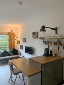cocina y sala de estar con mesa y sofá en The Corner en Bergen