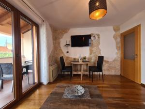 a living room with a table and chairs and a tv at Downtown Apartment Bepi in Opatija